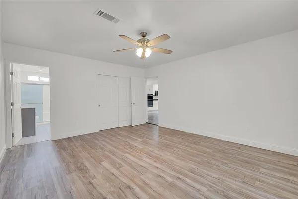 a view of empty room with wooden floor