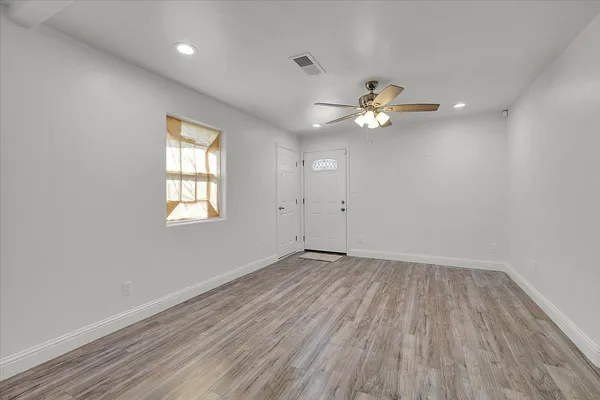 wooden floor in an empty room with a window