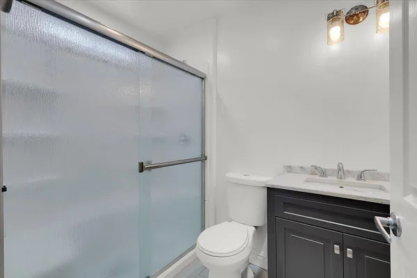 a bathroom with a sink a toilet and shower