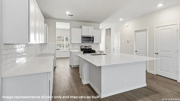a kitchen with kitchen island a counter top space a sink stainless steel appliances and cabinets