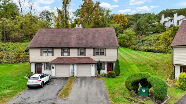 a aerial view of a house with table and chairs under an umbrella