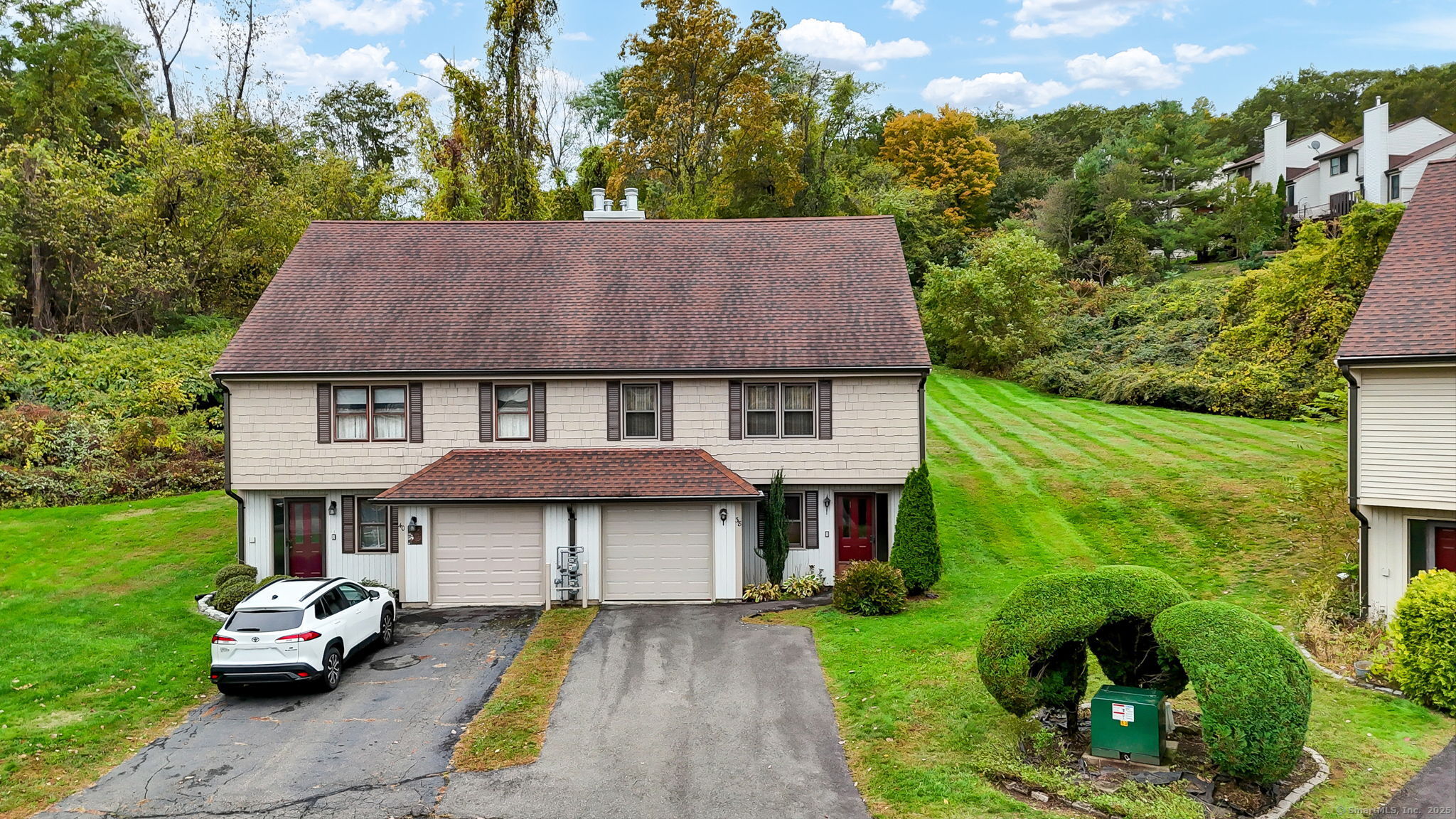 a aerial view of a house with table and chairs under an umbrella