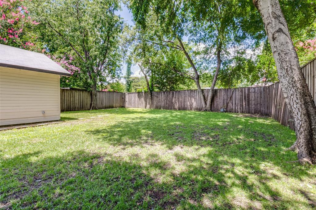 7127 East Mockingbird Lane Dallas, TX 75214 - Photo 23 of 31 a view of a backyard with a large tree and wooden fence