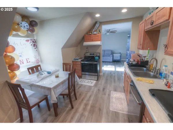 a kitchen with a wooden floor and chairs