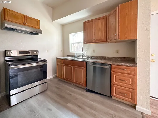 a kitchen with granite countertop wooden cabinets and stainless steel appliances