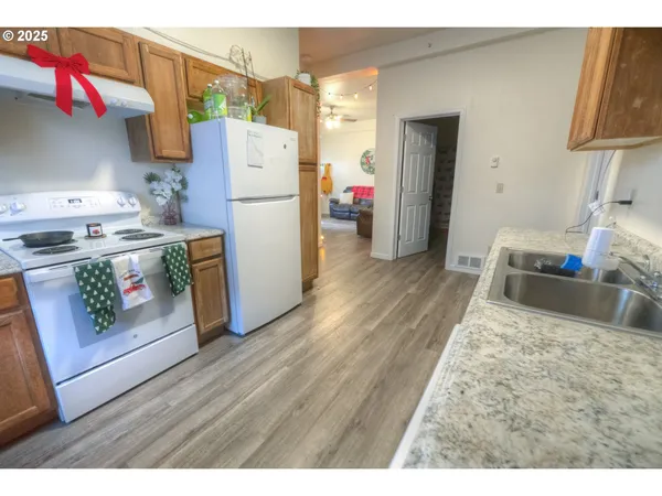 a kitchen with a refrigerator a stove and wooden floor