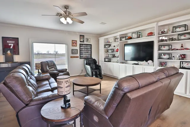 a living room with furniture a flat screen tv and a window