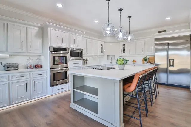 a kitchen with kitchen island granite countertop a sink a center island and cabinets