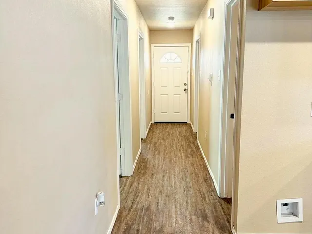 a view of a hallway with wooden floor