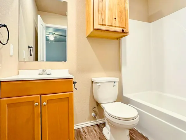 a bathroom with a granite countertop toilet sink and mirror