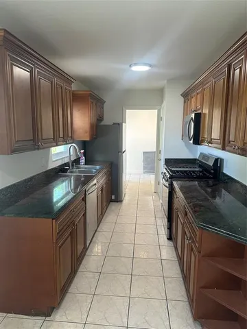 a kitchen with stainless steel appliances granite countertop a sink stove and cabinets