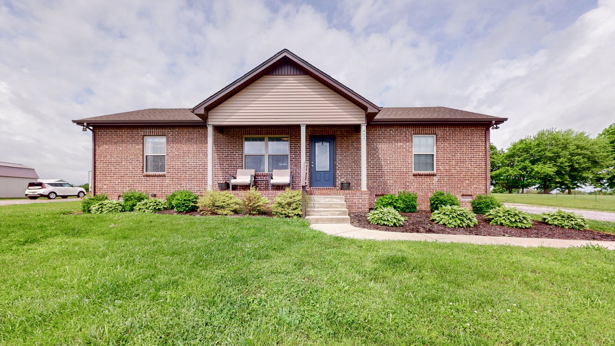 1462 East Ab Wade Road Portland, TN 37148 - Photo 1 of 52 a front view of a house with a garden and plants