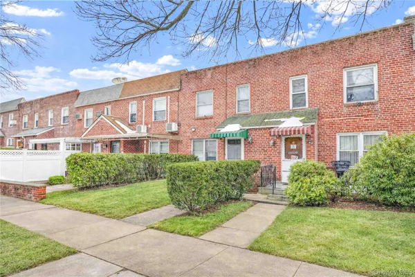 a view of a brick building next to a yard
