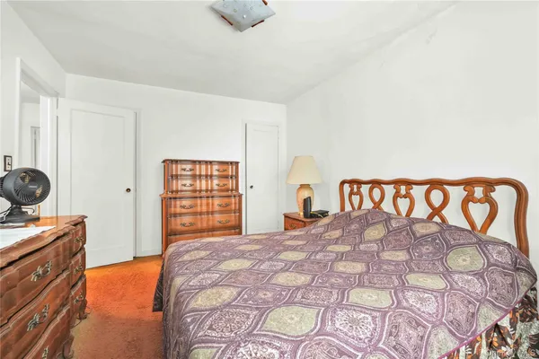 a view of an empty room with kitchen and a window