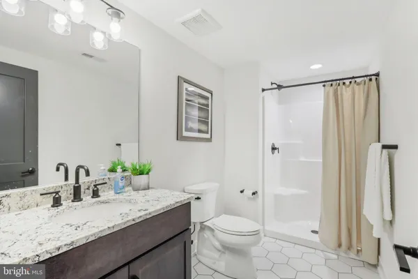 a bathroom with a granite countertop double vanity sinks and a mirror