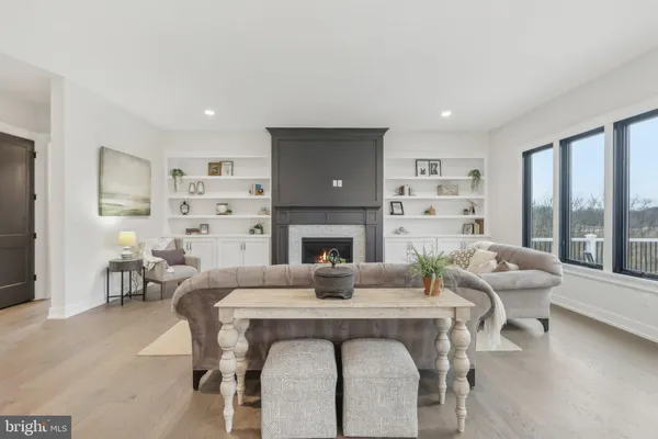 a living room with furniture a fireplace and a floor to ceiling window