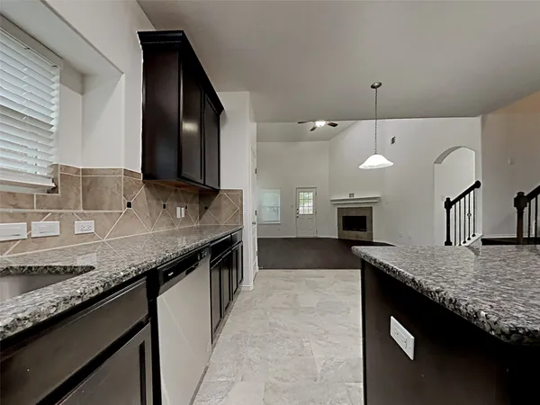 a kitchen with granite countertop kitchen island a sink stainless steel appliances and a counter space