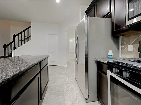 a kitchen with stainless steel appliances granite countertop a refrigerator and a stove