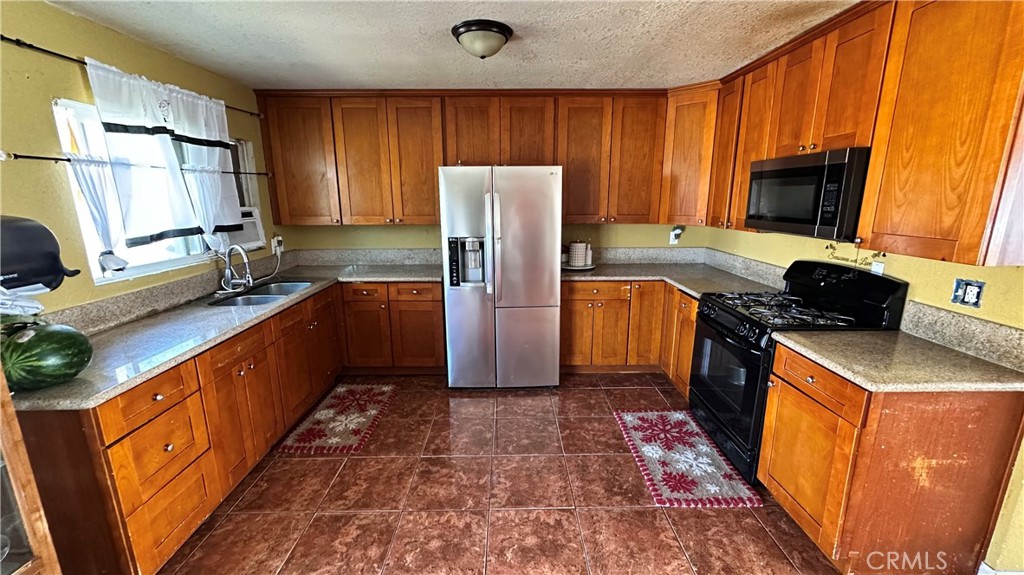 21290 Ellis Avenue Perris, CA 92570 - Photo 15 of 47 a kitchen with stainless steel appliances granite countertop a refrigerator stove and sink