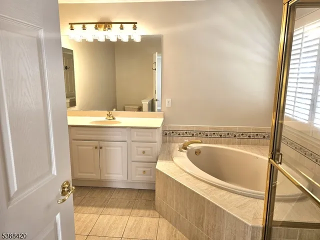 a bathroom with a tub sink and mirror