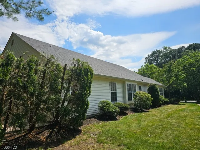 a view of a house with a yard and potted plants