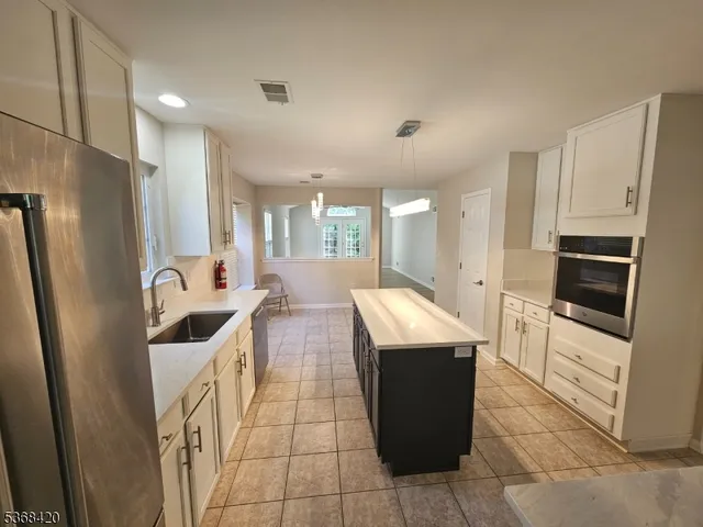 a kitchen with stainless steel appliances granite countertop a refrigerator and a stove