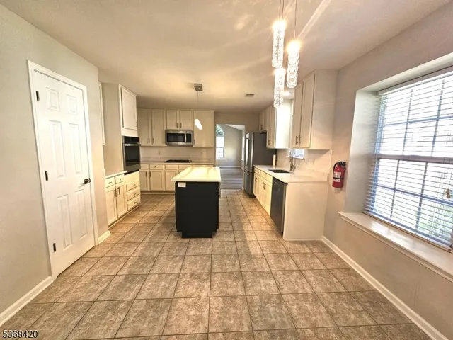 a large white kitchen with a stove a sink dishwasher and a refrigerator
