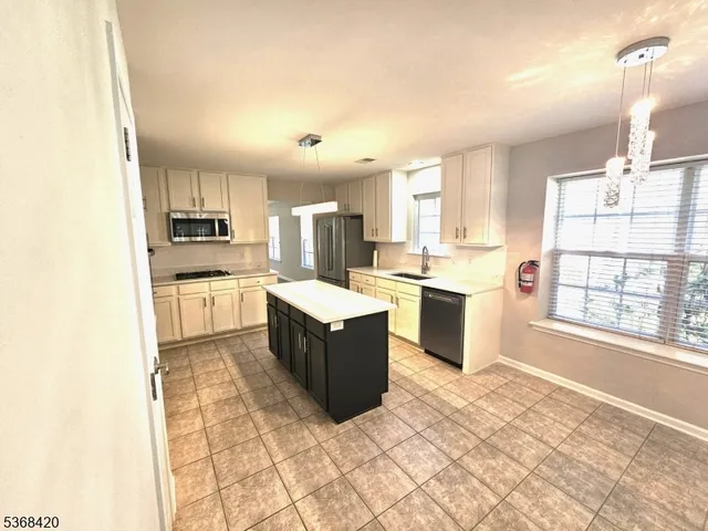 a large kitchen with a stove a sink a refrigerator and a microwave