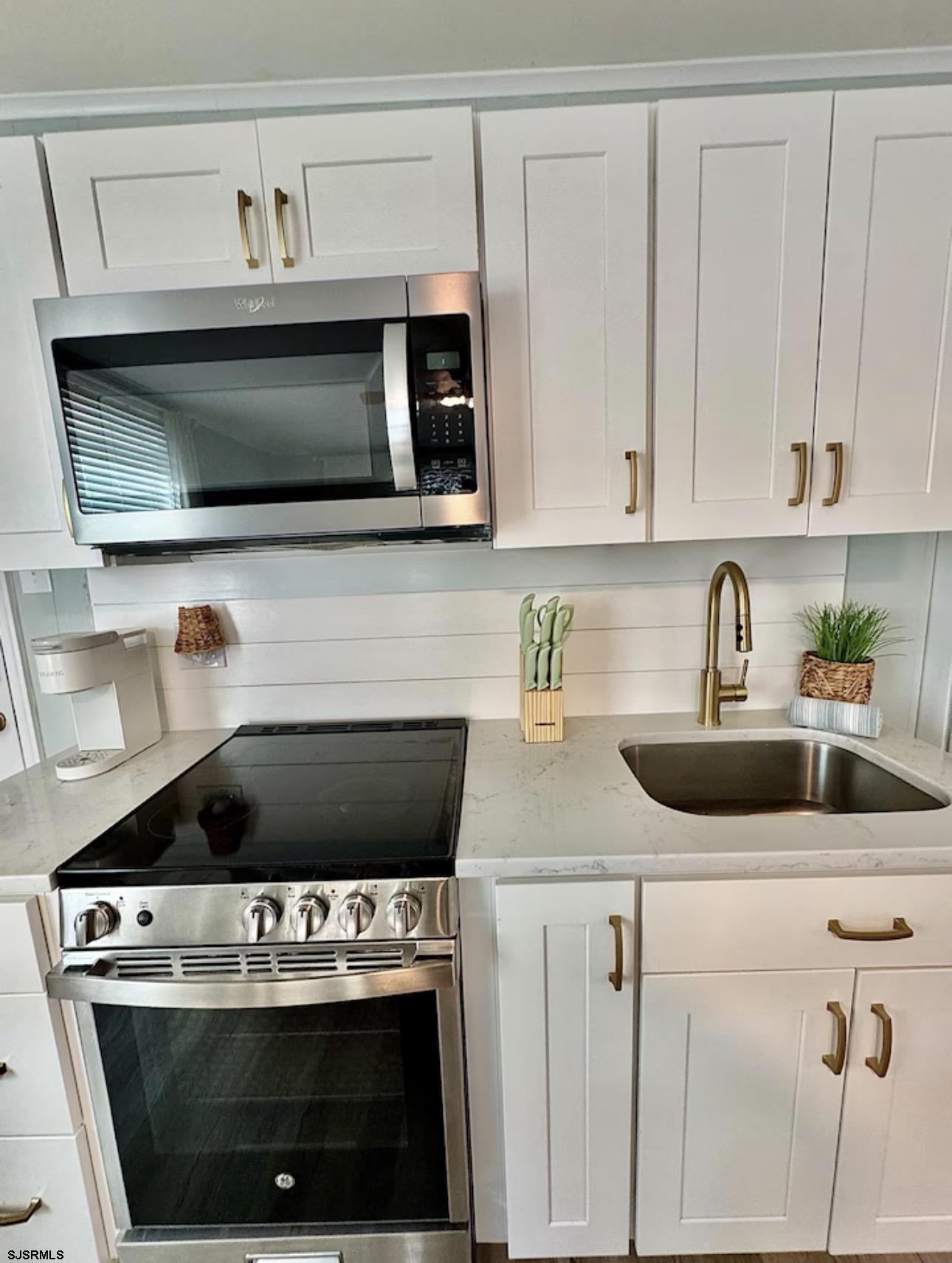 512 West Brigantine Avenue, Unit A Brigantine, NJ 08203 - Photo 12 of 26 a kitchen with white cabinets and black appliances