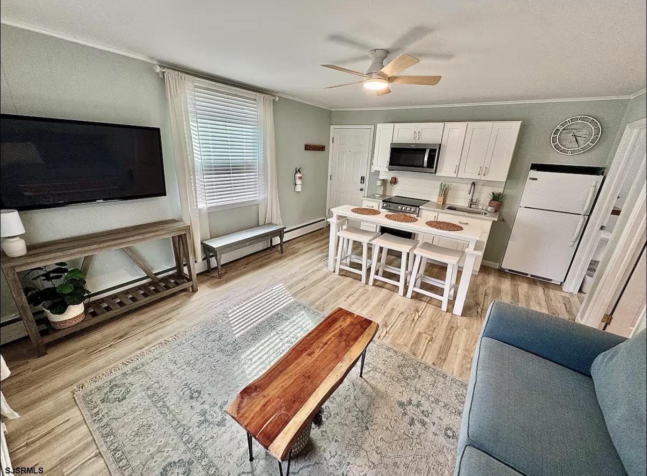512 West Brigantine Avenue, Unit A Brigantine, NJ 08203 - Photo 5 of 26 a living room with furniture a flat screen tv and a fireplace