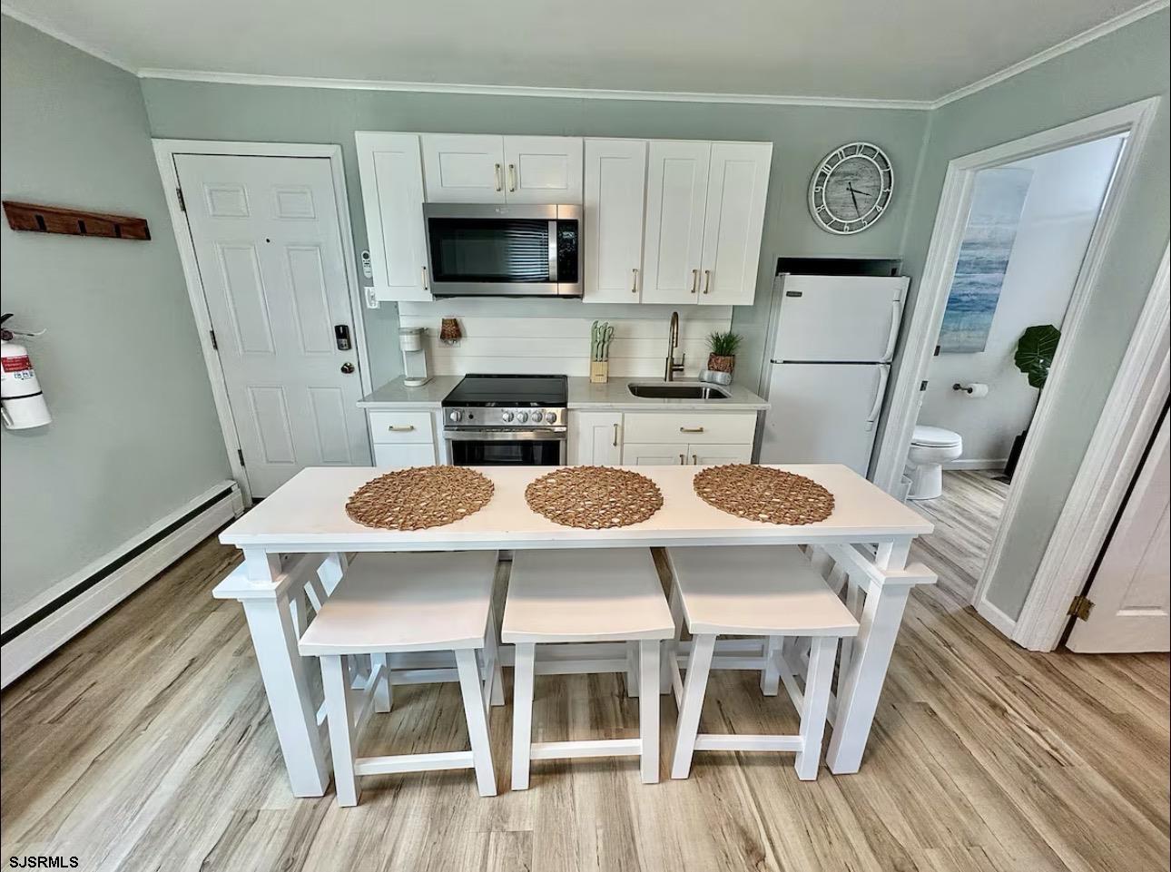 512 West Brigantine Avenue, Unit A Brigantine, NJ 08203 - Photo 6 of 26 a kitchen with stainless steel appliances granite countertop a stove a refrigerator a dining table and chairs