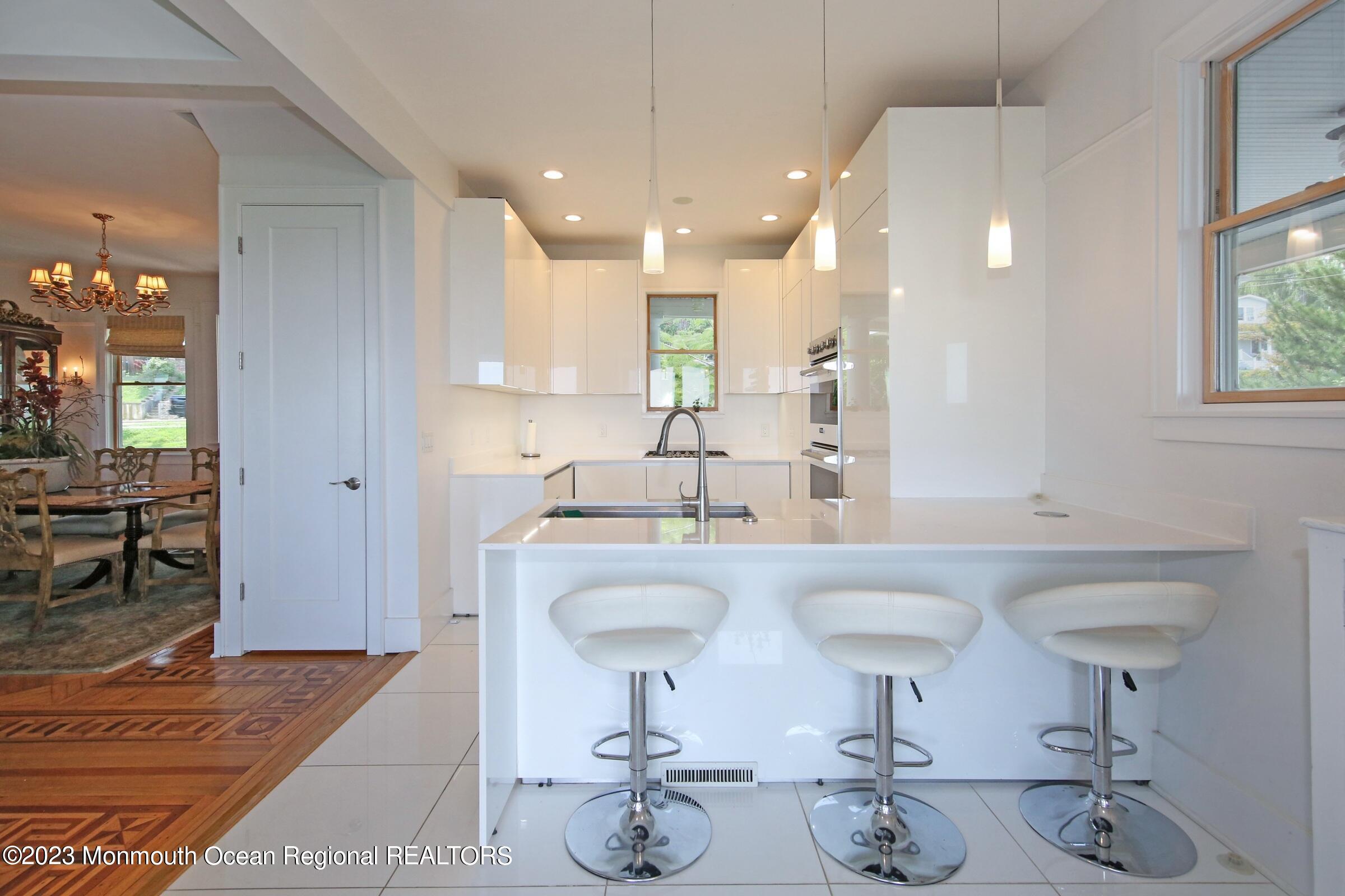 52 Navesink Avenue Highlands, NJ 07732 - Photo 51 of 71 a large kitchen with granite countertop a sink white cabinets and stainless steel appliances
