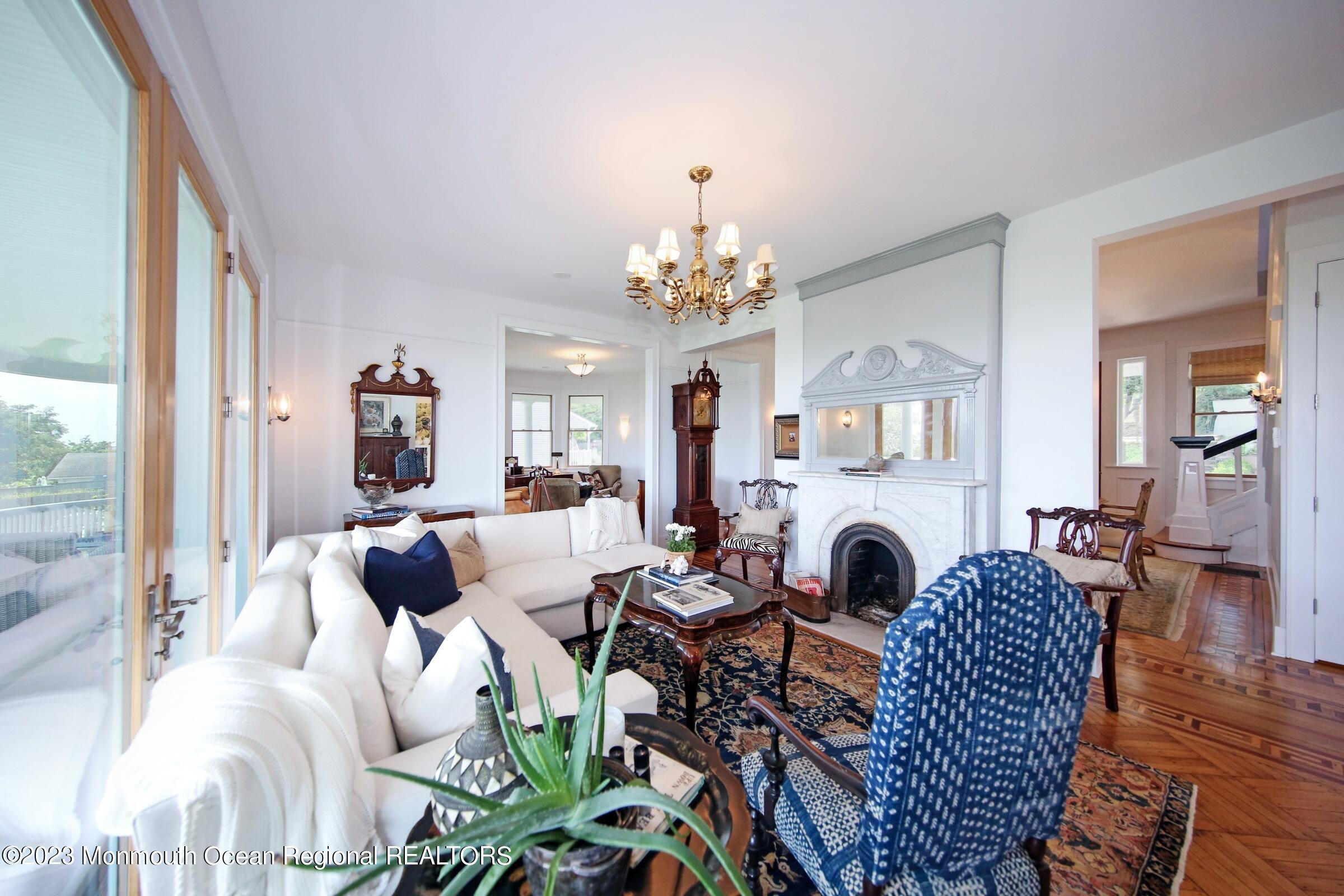 52 Navesink Avenue Highlands, NJ 07732 - Photo 71 of 71 a living room with furniture a fireplace and a chandelier