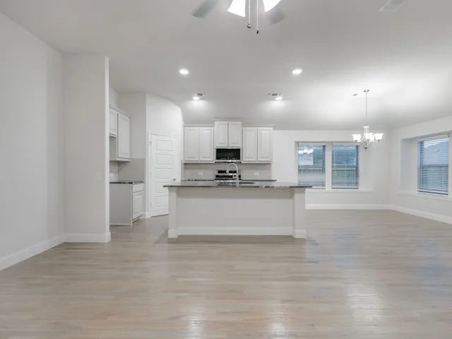 a view of kitchen with granite countertop cabinets and refrigerator