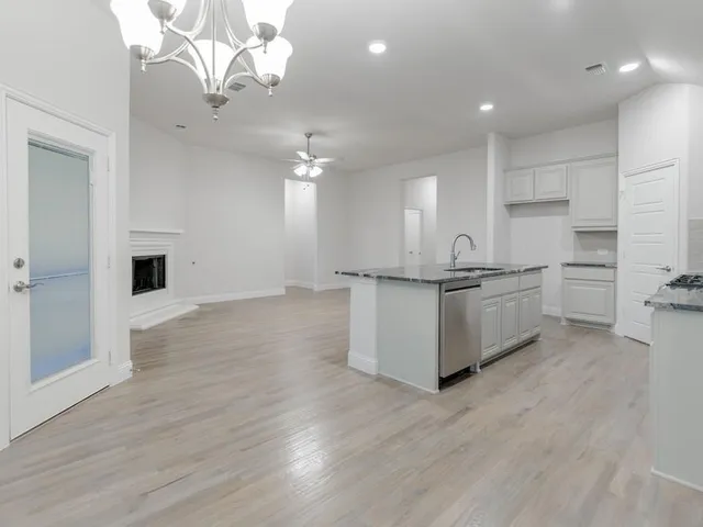 a view of kitchen with granite countertop stove top oven and cabinets