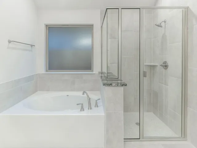 a white bath tub sitting next to a shower