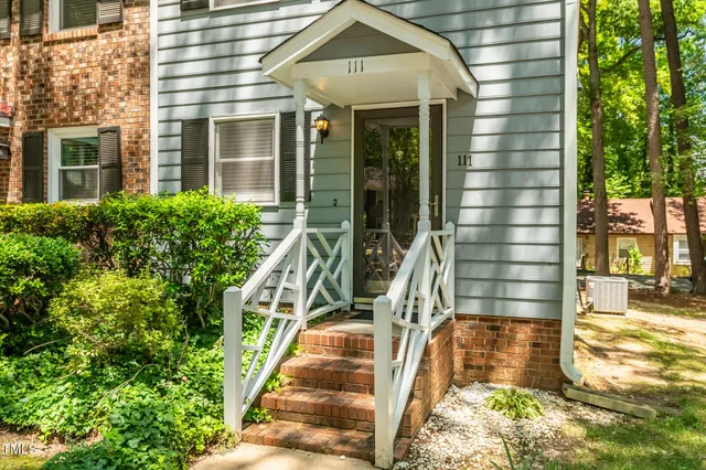 a view of a house with backyard and trees