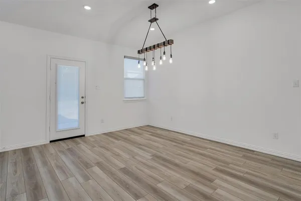 a view of empty room with wooden floor and ceiling fan