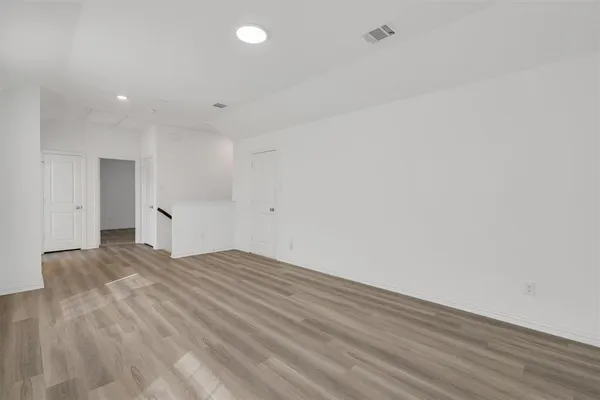 a view of empty room with wooden floor
