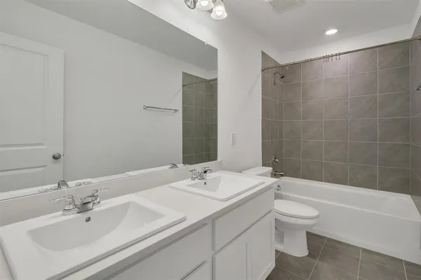 a bathroom with a bathtub shower sink mirror vanity and toilet