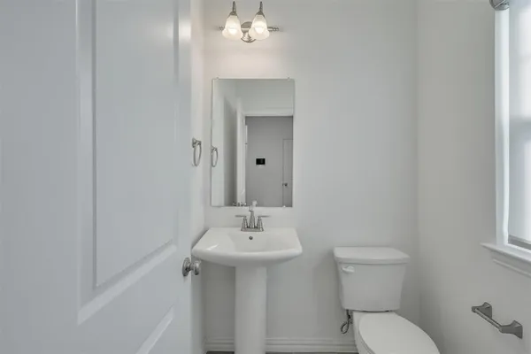 a bathroom with a toilet a sink and mirror