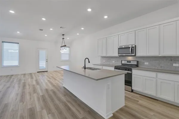 a kitchen with stainless steel appliances granite countertop a sink stove and cabinets