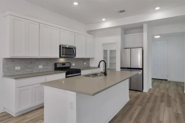 a kitchen with stainless steel appliances granite countertop a sink stove and microwave