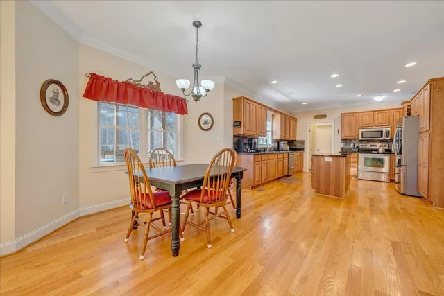 a kitchen with stainless steel appliances granite countertop a stove a sink dishwasher and a refrigerator with wooden floor