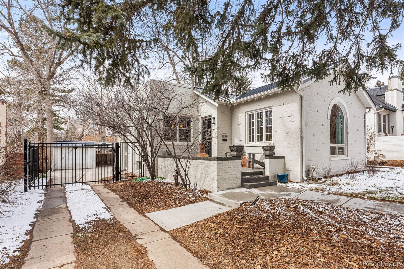 a front view of a house with a tree