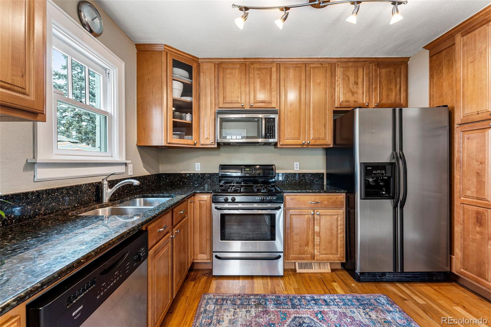 1639 Grape Street Denver, CO 80220 - Photo 12 of 39 a kitchen with granite countertop stainless steel appliances and wooden cabinets