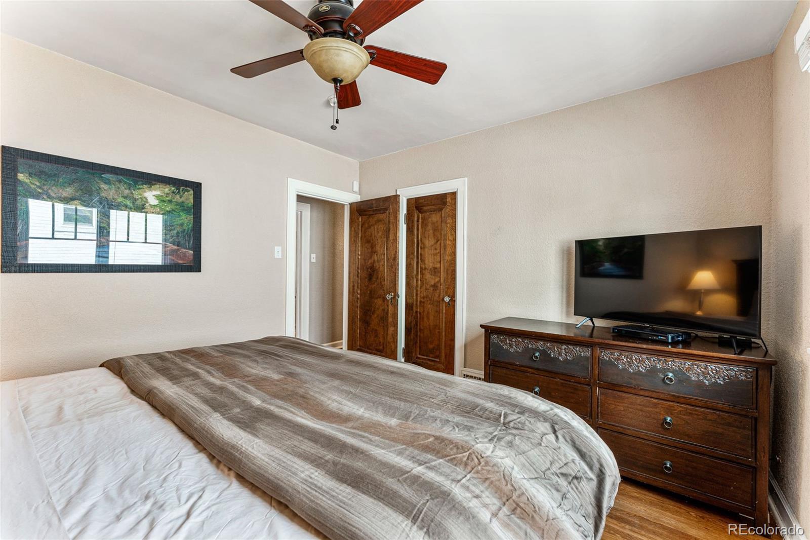 1639 Grape Street Denver, CO 80220 - Photo 17 of 39 a bedroom with a bed and a flat screen tv