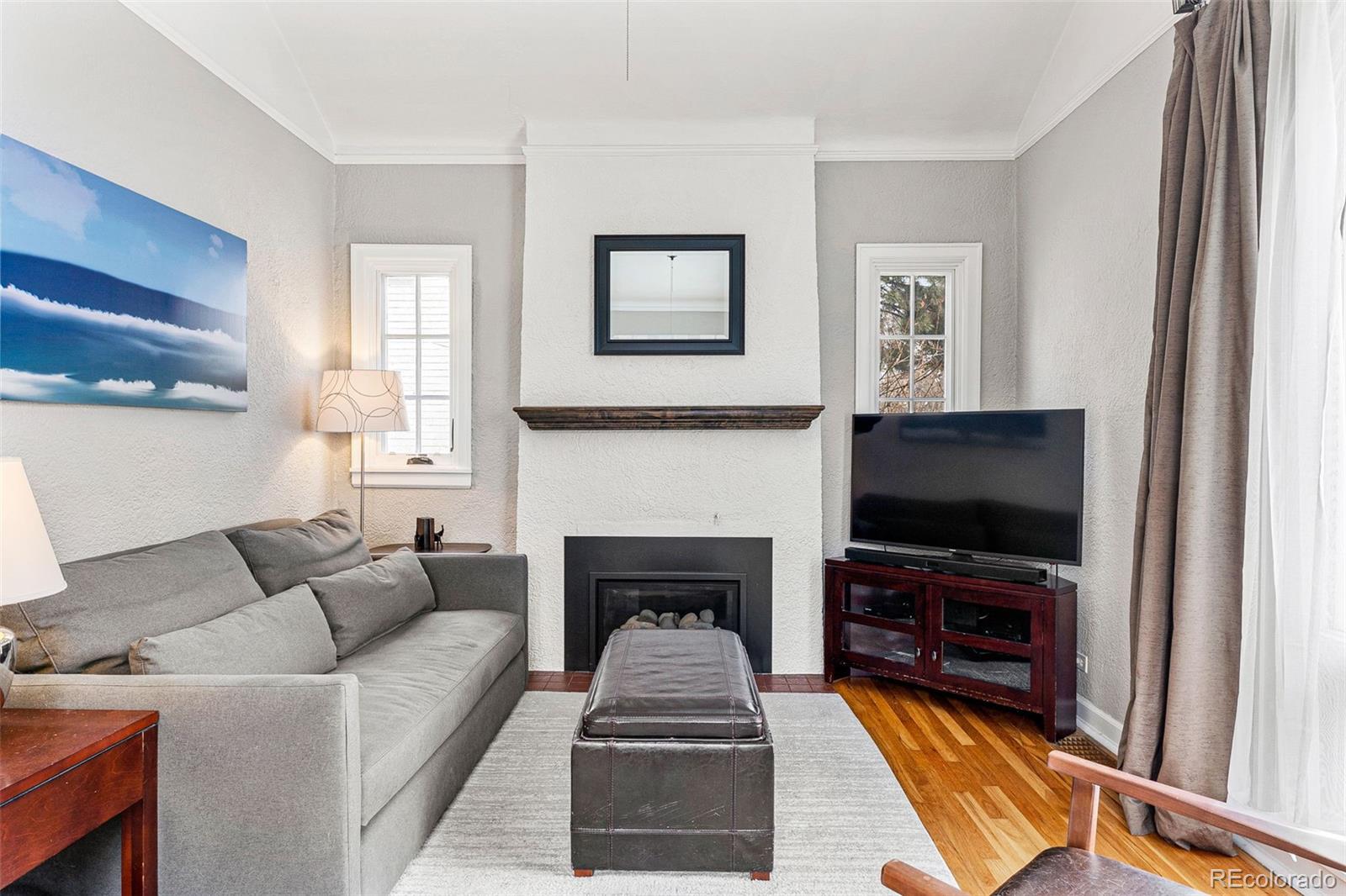 1639 Grape Street Denver, CO 80220 - Photo 5 of 39 a living room with furniture a flat screen tv and a fireplace