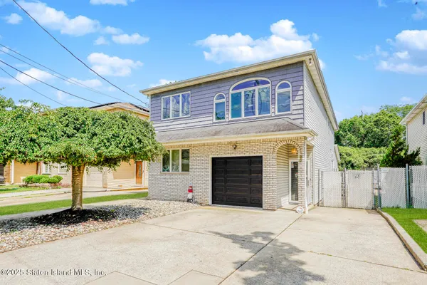 a front view of a house with a yard and a garage