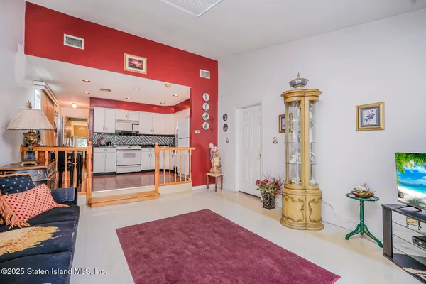 a living room with furniture a flat screen tv and kitchen view